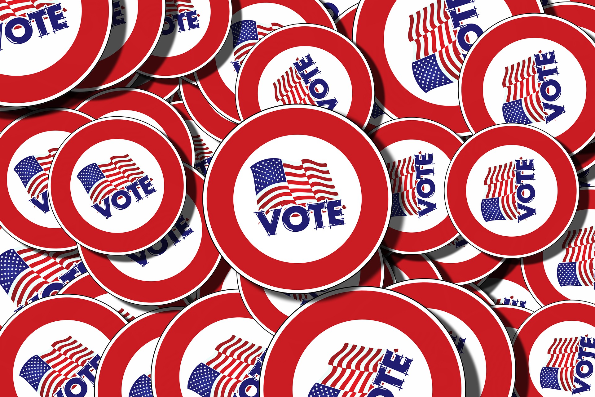 Piles of buttons with American flags saying VOTE.